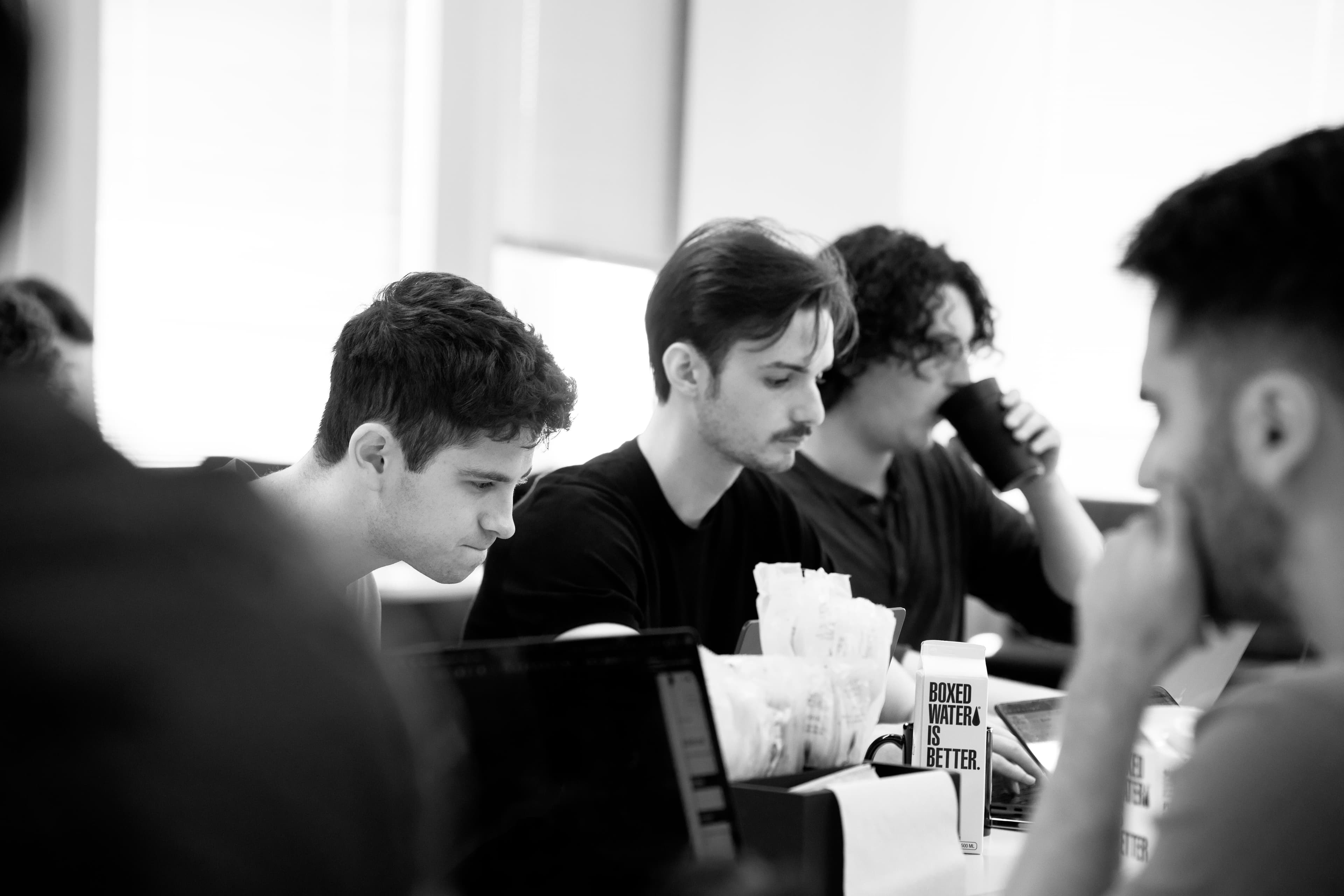 Participants working on laptops at a Vercel v0 community event