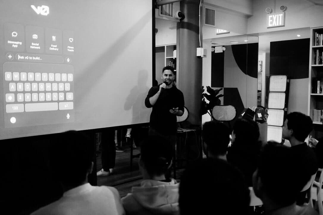 Speaker presenting on stage at a Vercel v0 community event